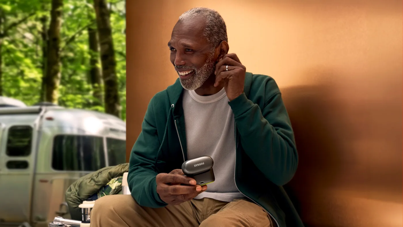 Utilisateur Phonak Audéo EON avec chargeur nomade en extérieur